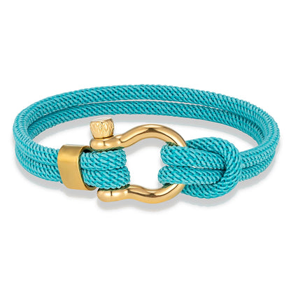 Pérignon Twist 
ein Armband wie ein Sommerabend am Hafen. Tauwerk und Goldschließe treffen auf den Luxus eines Champagner-Moments. Am besten getragen zum offenen Leinenhemd von Ralph Lauren – ein Detail, das nicht jeder versteht, aber die Richtigen.