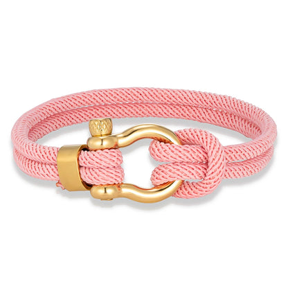 Pérignon Twist 
ein Armband wie ein Sommerabend am Hafen. Tauwerk und Goldschließe treffen auf den Luxus eines Champagner-Moments. Am besten getragen zum offenen Leinenhemd von Ralph Lauren – ein Detail, das nicht jeder versteht, aber die Richtigen.
