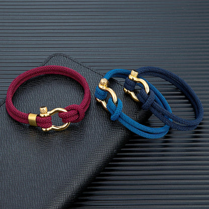 Pérignon Twist 
ein Armband wie ein Sommerabend am Hafen. Tauwerk und Goldschließe treffen auf den Luxus eines Champagner-Moments. Am besten getragen zum offenen Leinenhemd von Ralph Lauren – ein Detail, das nicht jeder versteht, aber die Richtigen.